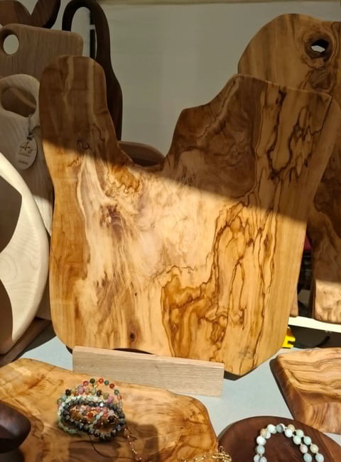 Wooden decorative cow head sculpture with natural grain patterns displayed among jewelry and wooden accessories